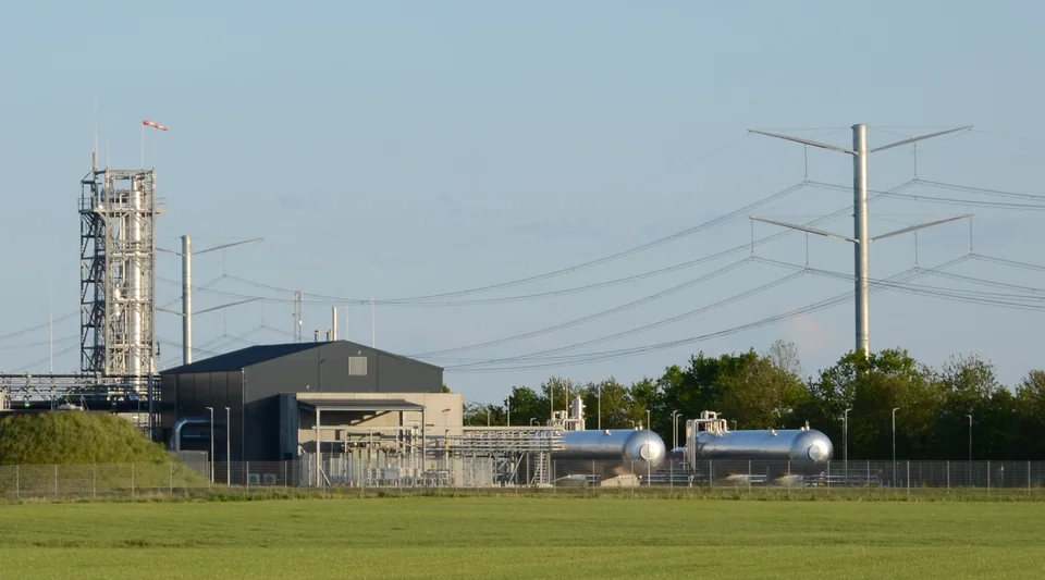A process column, plant building and vessels at an e-methanol facility.
